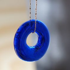 a blue glass donut hanging from a chain