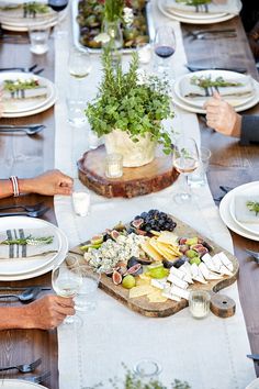 people sitting at a table with plates and wine glasses