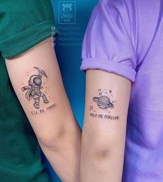 two people with matching tattoos on their arms, one is holding the other's arm