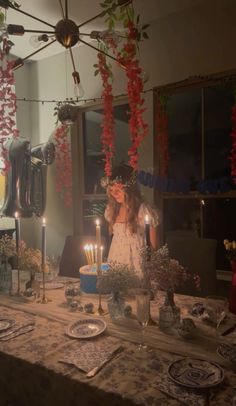 a woman standing in front of a table with candles