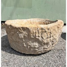 a large stone bowl sitting on top of gravel