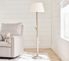 a living room with a chair, lamp and teddy bear on the rug in front of it