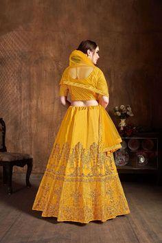 Look gorgeous in this Yellow colored bridal art silk designer lehenga for women beautified with floral zari embroidery all over enhanced by sequins & stone embellishments.
  Paired with a diagonal theme embroidery matching color choli in zari and sequins work paired with Yellow colored net dupatta with similar work embroidered lace details
It can be customized up to 42 inches. Silk Lehenga Designs, Silk Bridal Lehenga, Indian Wedding Lehenga, Bridal Art, Sabyasachi Lehenga, Yellow Lehenga, Wedding Dress Outfit, Zari Embroidery, Lehenga Style