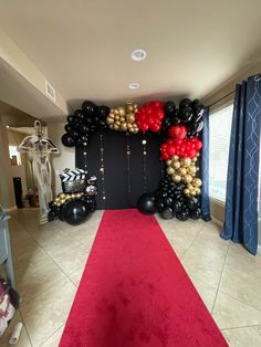 a red carpeted hallway with balloons and decorations on the wall, along with a red runner