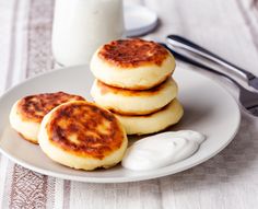 three pancakes on a plate next to a glass of milk