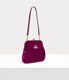 The Vivienne's clutch features a polished kiss-lock frame, reminiscent of early 20th-century antique coin purses, complete with antique gold plating. The piece receives a cotton velvet silhouette, complete with an embroidered orb on the front panel - embodying Vivienne's innovative vision of launching tradition into the future. Purple Vivienne Westwood, Velvet Purse, The Vivienne, Antique Coins, Into The Future, Socks And Tights, Knitwear Tops, Coin Purses, Watch Gifts