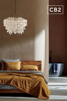 a bed sitting under a chandelier in a bedroom