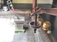 a person is pouring water into a bowl from a faucet in front of a door