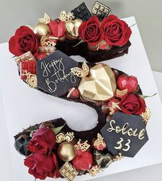 a birthday cake with roses and chocolates in the shape of the number 5 on it