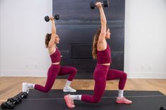 two women doing squats with dumbbells in front of an exercise room wall