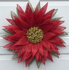 a red and gold mesh flower on a white door