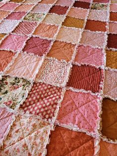 the quilt is made with many different colors and patterns, including pinks, oranges, yellows and browns