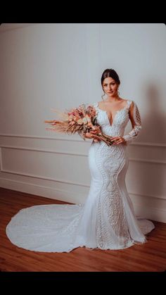 a woman in a wedding dress holding flowers