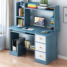 a computer desk with books and other items on top of it in front of a window