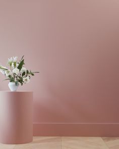 a pink vase with white flowers in it