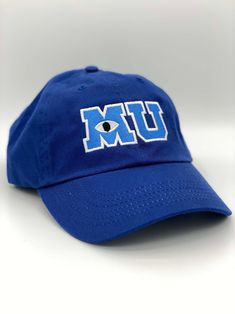 "Monsters University MU logo embroidered hat. Hat is made of 100% bio-washed chino twill Unstructured, six-panel, low-profile with pre-curved visor It has a tri-glide adjustable metal buckle closure Adult Size fit: 6 5/8\" - 7 3/8\" Youth/Toddler size fit: 6 1/2\" - 7 1/4\"" Monsters University Costumes, Mu Hat, Monsters University Hat, Monsters Inc Halloween, Sully Monsters Inc, Halloween Costume Adult, What To Wear To Disney, Boys Hats, School Costume