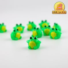 small green plastic frog figurines on a white surface