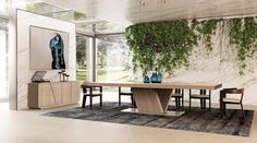 a dining room table with two vases sitting on top of it next to a plant covered wall