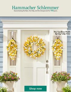 the front door is decorated with wreaths and potted plants for sale at hammacher schlemmer