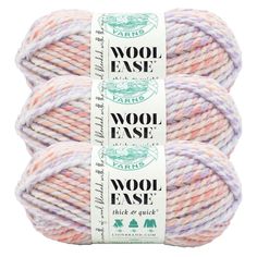 three skeins of wool ease yarn in pink, purple and white colors on a white background