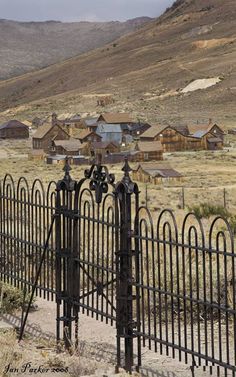 an iron fence and gate in the middle of nowhere