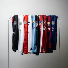 there are many different soccer jerseys hanging on the rack