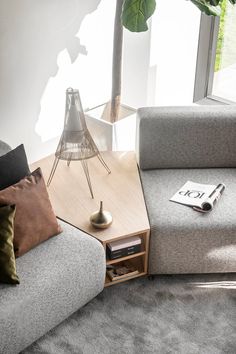 a living room with two couches and a table in front of a large window