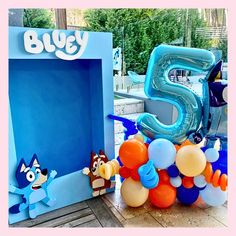 an image of a birthday party with balloons and balloon animals on the table in front of it