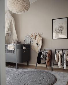 a baby's room is shown with clothes hanging on the rack and other items