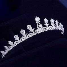 Adorned with intricately faceted clear cubic zirconia that work their way across the band in a swirly pattern and capturing the light from every angle with a perfectly translucent appeal, this delicate tiara can complete the most sophisticated of bridal looks. Cast in lightweight alloy and rhodium plated for a flawless finish, the headband measures 1.25" at the highest point (approx. 3cm) and 5.5" across (approx. 14cm). Two small loops at each end make it easy to attach to your hair with bobby p Elegant Crystal Headpieces For Weddings, Adjustable Crown Design Headpiece For Weddings, Wedding Crown With Rhinestones And Pinched Shape, Teardrop Crown Jewelry With Rhinestones For Wedding, White Crown Design Jewelry For Wedding, Elegant Crystal Crown For Wedding, Elegant Silver Crown With Rhinestones, Silver Wedding Crown With Rhinestones, Silver Rhinestone Wedding Crown