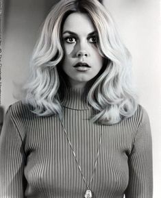 a black and white photo of a woman with blonde hair wearing a turtle neck sweater