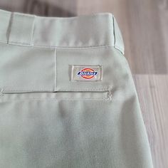 This Pair Of Men's Dickies 874 Utility Khaki Pants Has A Classic 4-Pocket Design With Slash Pockets, Perfect For Casual Or Workwear Occasions. The Pants Feature A Straight Leg Style With A Flat Front And A Mid-Rise Of 10-12 Inches. The Waist Size Is 40 Inches And The Inseam Measures 34 Inches. Made With A Woven Cotton Fabric That Has Been Preshrunk, These Pants Are Machine Washable And Have A Medium Fabric Wash. They Come In A Solid Beige Color And Have Button And Zipper Closures. The Pants Have Classic Khaki Bottoms With Hip Pockets, Flat Front Cotton Work Pants With Pockets, Classic Khaki Pants With Pockets, Classic Khaki Bottoms With Patch Pockets, Cotton Straight Leg Bottoms With Open Pocket, Classic Khaki Bottoms With Side Pockets, Classic Khaki Cargo Pants With Pockets, Classic Khaki Cargo Pants, Classic Khaki Cargo Pants With Belt Loops