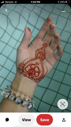 a woman's hand with hendix on it and some beads around her wrist