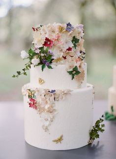 a wedding cake decorated with flowers and butterflies