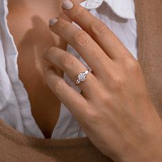 a woman's hand with a diamond ring on it