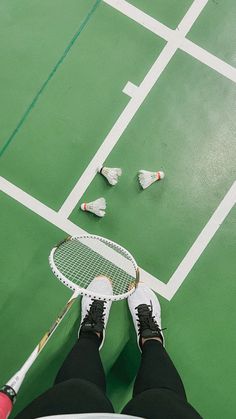 a person standing on a tennis court holding a racquet in their right hand