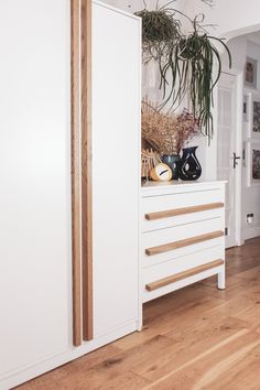 a white cabinet sitting next to a wooden floor