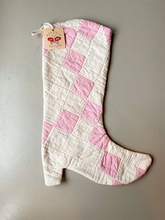 a pink and white quilted stocking hanging on a wall