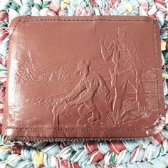 a brown leather wallet sitting on top of a rug