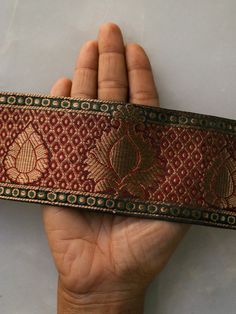 Banarasi brocade in traditional red and gold. This gorgeous trim is created with Banarasi brocade weave, with floral and regal motifs woven in gold on to a deep red fabric. With a bit of dark green to bring more depth to the pattern. The colour combination and muted gold give a very vintage and royal look to the trim. And to any project you use it on. Price for 1 mtr Size - 7 cm W Use it to embellish your denim jackets, or border your sarees. Or create home décor like lamps or curtain ties. Or a Festive Traditional Wear With Jamawar Border, Diwali Traditional Jamawar Wear With Border, Festival Jamawar Traditional Wear With Border, Red Semi-stitched Traditional Wear With Border, Red Anarkali Traditional Wear With Border, Festive Jamawar Traditional Wear With Border, Semi-stitched Gold Traditional Wear With Border, Red Tussar Silk Dupatta With Border, Traditional Dupatta With Border For Puja