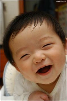 a close up of a baby smiling with its mouth open