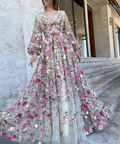 Imaginez-vous dans un magnifique jardin de fleurs sauvages, entouré de fleurs épanouies dans toutes les directions. Le soleil brille, la brise est douce et vous portez la magnifique robe en tulle Yana Garden. Cette robe incarne l'essence d'une garden-party fantaisiste, avec son tissu en tulle délicat, ses manches bouffantes ludiques et sa broderie florale complexe.

La silhouette A-line est universellement flatteuse, accentuant vos courbes et créant une forme de sablier de rêve. L'encolure en V profonde ajoute une touche d'élégance, tandis que la longue traîne ajoute une touche de glamour. Confectionnée à partir de tulle, d'élasthanne et de polyester de haute qualité, cette robe formelle pour femme a une coupe confortable et flatteuse, avec un soutien-gorge intégré pour un soutien accru. Feminine Floral Embroidered Gown For Spring, Feminine Spring Gown With Floral Embroidery, Spring Wedding Maxi Dress With Floral Embroidery, Maxi Length Floral Applique Dress For Garden Party, Maxi Length Dress With Floral Applique For Garden Party, Feminine Floral Embroidered Maxi Dress For Garden Party, Spring Floral Applique Maxi Dress For Garden Party, Feminine Maxi Dress With Floral Embroidery For Garden Party, Floral Embellished Dress For Garden Party