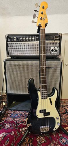 an electric bass guitar sitting on top of a rug