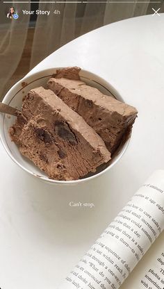 a bowl filled with brownies next to an open book