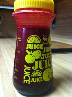 a bottle of juice sitting on top of a wooden table