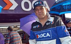 a man standing in front of a sign holding an umbrella