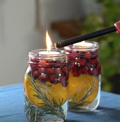 two mason jars filled with lemons and cranberries on top of a table