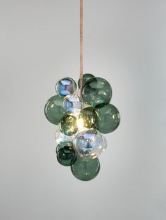 a green and clear light hanging from a cord