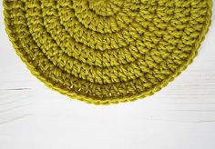 a yellow crocheted dishcloth on a white wooden surface