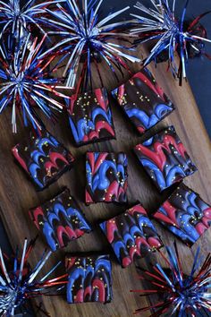 some red, white and blue cookies are on a cutting board with fireworks in the background